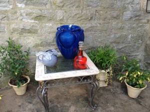 solid glass-top table holds splashing fountain and other accessories.